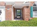 Close-up of the home's entryway showcasing a decorative glass door, brick facade, and bright green shutters at 1152 Strath Clyde Way, Mcdonough, GA 30253