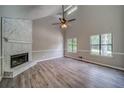 Inviting living room featuring a vaulted ceiling, cozy fireplace, and large windows that let in plenty of natural light at 3260 Sims View Ct, Snellville, GA 30078
