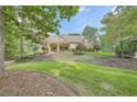 Well-manicured front lawn with mature trees accentuates the attractive facade of this home at 3270 New University Trl, Cumming, GA 30041