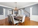 Formal dining room with hardwood floors, wainscoting, elegant chandelier, and view to foyer at 4080 Glen Hill Ne Way, Marietta, GA 30066