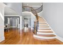 Grand foyer showcasing a curved staircase, hardwood floors, wrought iron railing, and arched entryway at 4080 Glen Hill Ne Way, Marietta, GA 30066