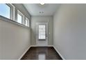 Bright entryway featuring hardwood floors, neutral paint and a door with glass and blinds at 68 Hardy Water Dr, Lawrenceville, GA 30045