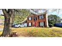Charming brick two-story home with manicured lawn and a bright red front door at 3897 Vine Stone Dr, Stonecrest, GA 30038