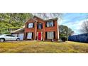 Charming brick two-story home with manicured lawn and a red front door at 3897 Vine Stone Dr, Stonecrest, GA 30038