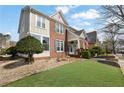 Attractive home with a manicured lawn, brick accents, and a cozy front porch with an American flag at 525 Village Arbor Park, Suwanee, GA 30024