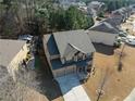 Aerial view of a two-story home with a spacious driveway and well-maintained lawn in a residential neighborhood at 6545 Muirfield Pt, Fairburn, GA 30213
