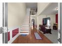 Inviting entryway with hardwood floors, staircase, and views into the living and dining areas at 6545 Muirfield Pt, Fairburn, GA 30213