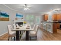 Bright dining room with a modern table set, hardwood floors, and a view to the kitchen at 145 Sunset Ln, Woodstock, GA 30189