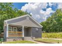 Detailed view of the home's gray siding, black brick accents, and a welcoming front porch at 299 Fletcher Street Sw, Atlanta, GA 30315