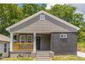 Front view of the home featuring gray siding, black brick, front porch, and well-manicured lawn at 299 Fletcher Street Sw, Atlanta, GA 30315