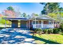 Single-story brick home with attached carport, covered porch, and a well manicured lawn at 5042 Central Church Rd, Douglasville, GA 30135