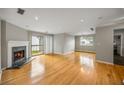 Spacious living room with hardwood floors, fireplace, and sliding door to the outdoor balcony at 30 Finch Ne Trl, Atlanta, GA 30308