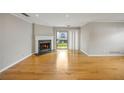 Bright living room with hardwood floors and fireplace; sliding door to balcony offers scenic views at 30 Finch Ne Trl, Atlanta, GA 30308