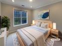 Bright bedroom featuring a comfortable bed, stylish decor, a large window, and soft lighting at 45 Fiddle Crk, Social Circle, GA 30025