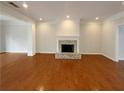 Spacious living room featuring hardwood floors and a classic fireplace, offering a versatile space at 45 Fiddle Crk, Social Circle, GA 30025