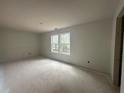 The unfinished bedroom features a large window, providing natural light at 75 Emerald Ln, Covington, GA 30014