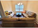 Cozy living room features a comfortable leather sectional sofa near a bright window at 1125 Campbell Pine Trl, Lawrenceville, GA 30045