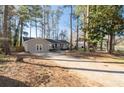 Expansive driveway leads to the lovely single-story home surrounded by lush, mature trees and new wood fence at 2014 Poplar Rdg, Lawrenceville, GA 30044