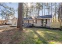A well-maintained home featuring neutral siding, black shutters and inviting front yard with landscaped details at 2014 Poplar Rdg, Lawrenceville, GA 30044