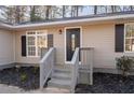 Close-up of the home's entrance, highlighting the porch, black door, and updated landscaping for curb appeal at 2014 Poplar Rdg, Lawrenceville, GA 30044