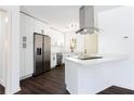 Modern white kitchen featuring stainless steel appliances, a peninsula island, and dark hardwood flooring at 618 Farrar Ct, Decatur, GA 30032