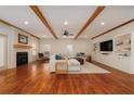 Spacious living room featuring hardwood floors, a cozy fireplace, built-in shelving, and exposed wood beams, creating an inviting atmosphere at 827 Derrydown Way, Decatur, GA 30030