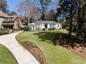 An inviting front yard of this home offers a well-manicured lawn and a concrete driveway leading up to the house at 1015 Peachtree Battle Cir, Atlanta, GA 30327