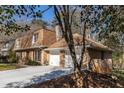 Side view of a charming brick home featuring an attached garage and well-maintained yard at 1135 Banbury Cross, Avondale Estates, GA 30002