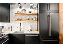 Well-lit modern kitchen featuring floating shelves, black cabinets and stainless appliances at 170 Boulevard Se # H213, Atlanta, GA 30312