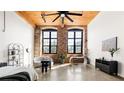 Spacious living room featuring exposed brick walls, wood ceiling beams and large windows at 170 Boulevard Se # H213, Atlanta, GA 30312