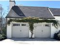Attached two-car garage adorned with climbing vines, adding a touch of nature and curb appeal at 5210 Timber S Trl, Sandy Springs, GA 30342