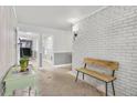 Bright hallway with light-colored brick wall and minimalist decor, featuring tile floors and a wooden bench at 395 Pharr Ne Rd # 305, Atlanta, GA 30305