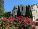 Beautiful two-story home with well-manicured lawn and vibrant flowering bushes under a clear blue sky at 1919 Barrett Knoll Nw Cir, Kennesaw, GA 30152