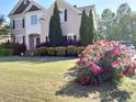 Charming home with a well-manicured lawn and vibrant pink roses in the front yard at 1919 Barrett Knoll Nw Cir, Kennesaw, GA 30152