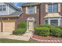 Close-up of the front door with brick facade and manicured landscaping and flower bed at 3370 Flagstone Trce, Ellenwood, GA 30294
