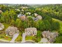 Aerial view of a neighborhood with luxurious homes nestled among mature trees and lush landscaping at 4827 Basingstoke Dr, Suwanee, GA 30024