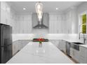 Elegant white kitchen with a large island, stainless steel appliances, and a stylish backsplash at 4827 Basingstoke Dr, Suwanee, GA 30024