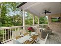 Covered outdoor patio featuring comfortable seating, dining area, ceiling fan, and view of lush greenery at 4827 Basingstoke Dr, Suwanee, GA 30024