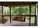 Relax on the covered porch with a swing and enjoy the wooded scenery at 59 Pine Ridge Ln, White, GA 30184