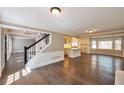 Open-concept living space with hardwood floors, stylish staircase, and views into the adjacent kitchen at 1095 Willow Bnd, Roswell, GA 30075