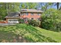 Beautifully landscaped front yard of a two-story brick home with a two-car garage at 1527 Ridgewood Sw Dr, Lilburn, GA 30047