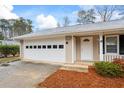 Attached two car garage with white door and mulched landscaping leading to the front door entrance at 334 Nancy Sw Ct, Lilburn, GA 30047