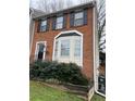 Inviting two-story townhome with brick facade, black shutters, and manicured landscaping at 1672 Cedar Bluff Way, Marietta, GA 30062