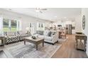 Open-concept living room with hardwood floors, modern decor, and seamless flow to the kitchen and dining area at 11102 Suria Dr, Conyers, GA 30014