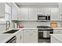 Bright kitchen featuring white cabinets, stainless steel appliances, subway tile backsplash, and sleek countertops at 2376 Wellington Cir, Lithonia, GA 30058