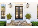 Inviting front door with stone steps, black framed windows, and potted shrubbery at 3034 Farmington Se Dr, Atlanta, GA 30339