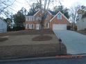 Beautiful brick home with a two-car garage, manicured lawn and a tree in the yard at 3975 Broadleaf Walk, Ellenwood, GA 30294