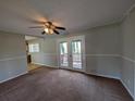 Cozy living room with ceiling fan, carpet flooring and access to outdoor deck at 8271 Walnut Dr, Jonesboro, GA 30238