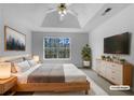 Relaxing bedroom featuring tray ceilings, a serene view and natural light at 1486 Waterton Trl, Douglasville, GA 30134