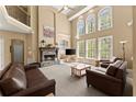 Bright living room with soaring ceilings, a fireplace, large windows, and comfortable seating at 6165 Lake Oak Lndg, Cumming, GA 30040